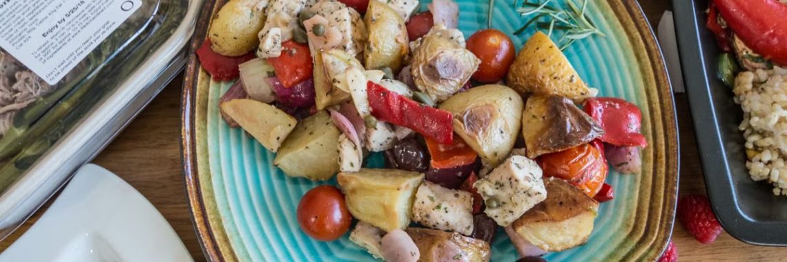 Delicious Mediterranean meal with roasted vegetables and herbs on a turquoise plate, ideal for healthy eating promotions.
